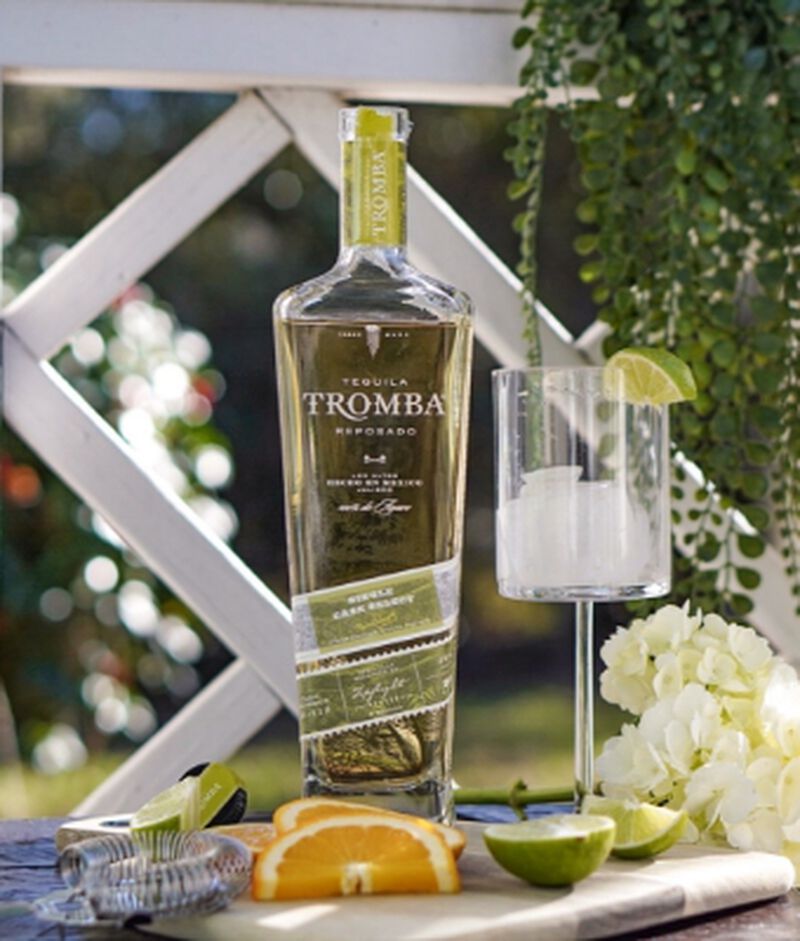 Bottle of Tequila Tromba Single Barrel Reposado S1B48 with cocktail ingredients in front of greenery