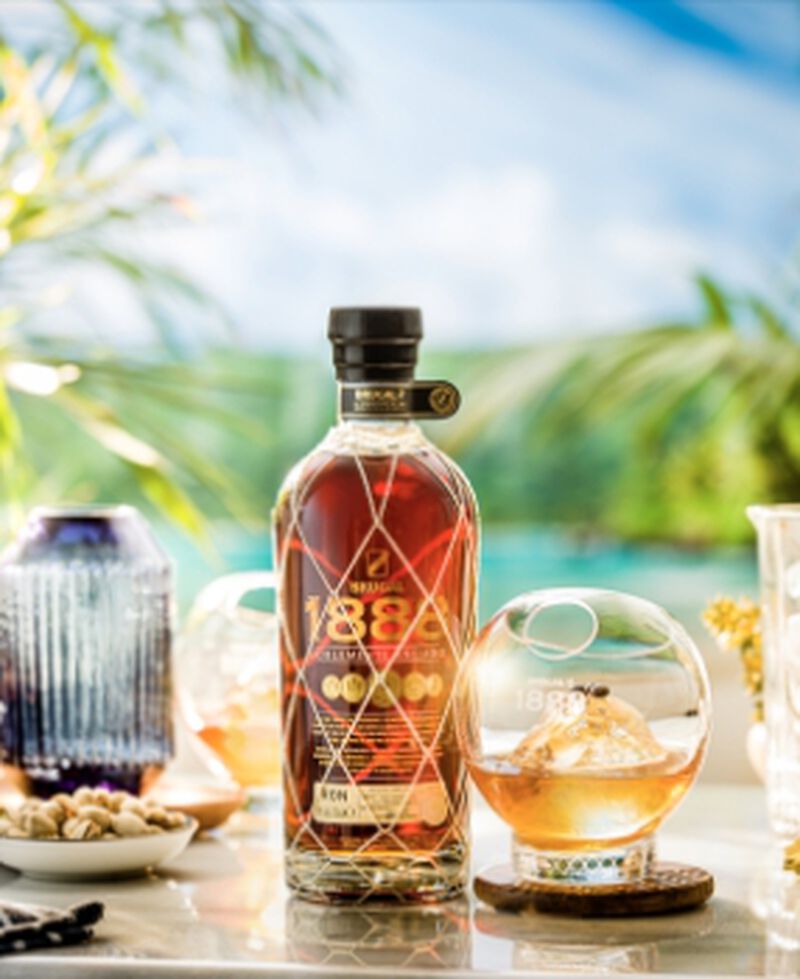 Bottle of Brugal 1888 with cocktails in a tropical setting