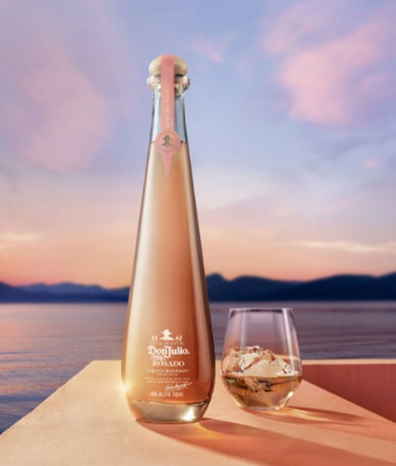 Bottle of Don Julio Rosado in front of pastel sky and water