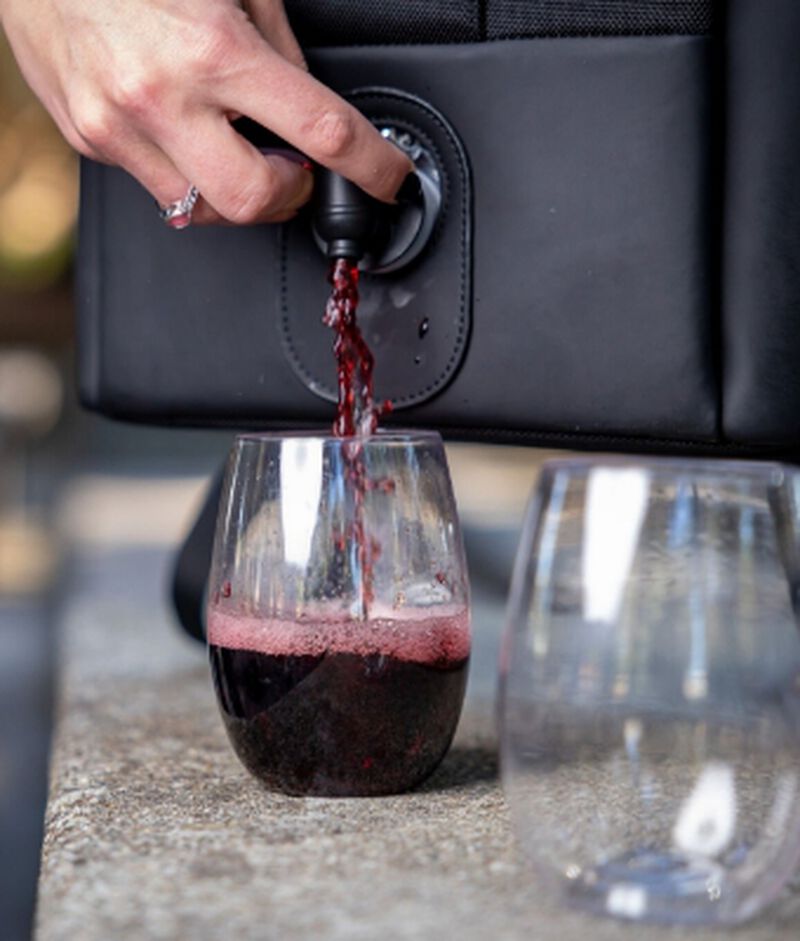 wine being poured into a glass from a VinXplorer Wine & Beverage Backpack