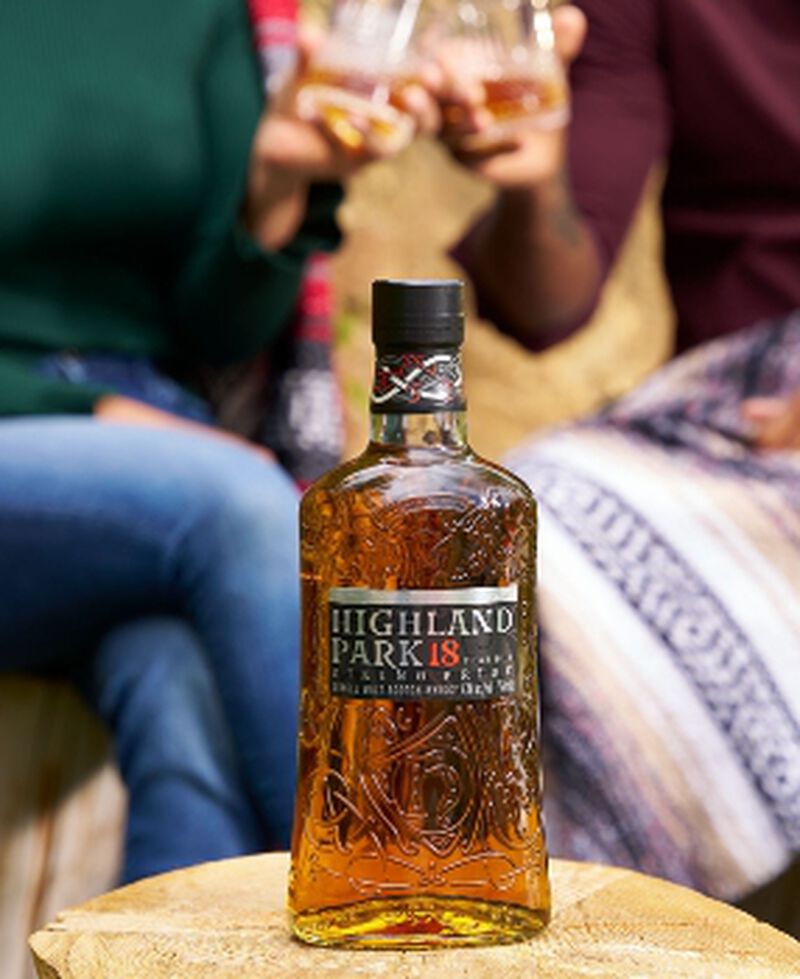 Bottle of Highland Park 18 Year Old Single Malt Whiskey being enjoyed by two people