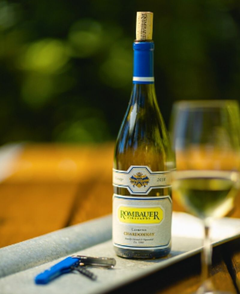 A bottle of Rombauer Carneros Chardonnay with a glass of wine outside