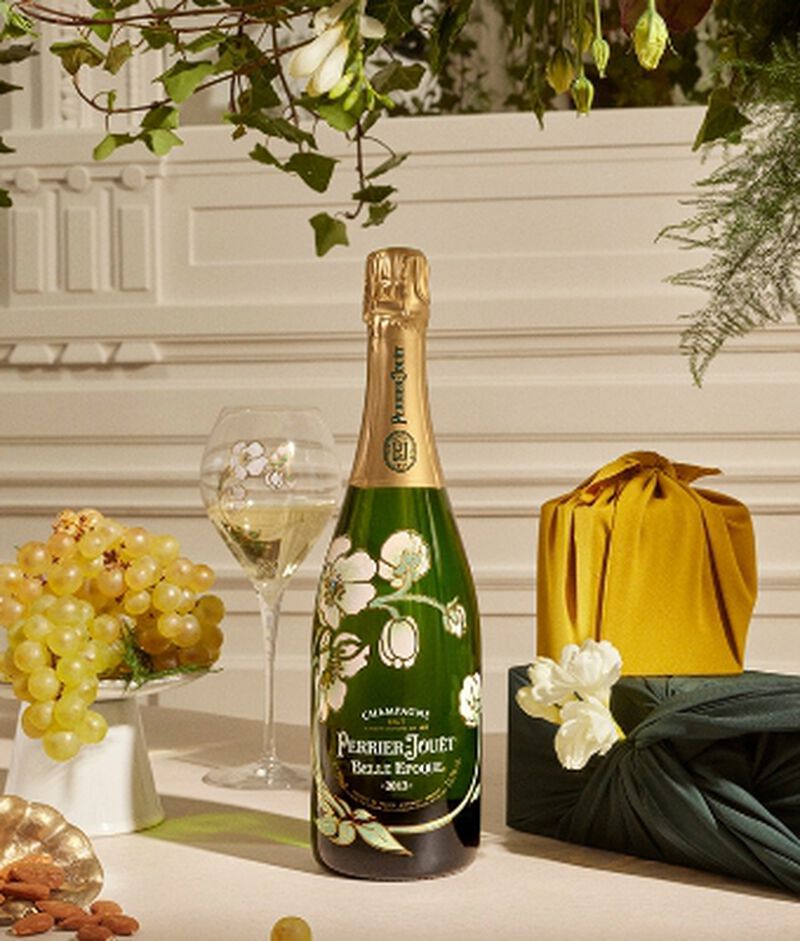 Bottle of Perrier-Jouet Belle Epoque with a champagne flute and grapes