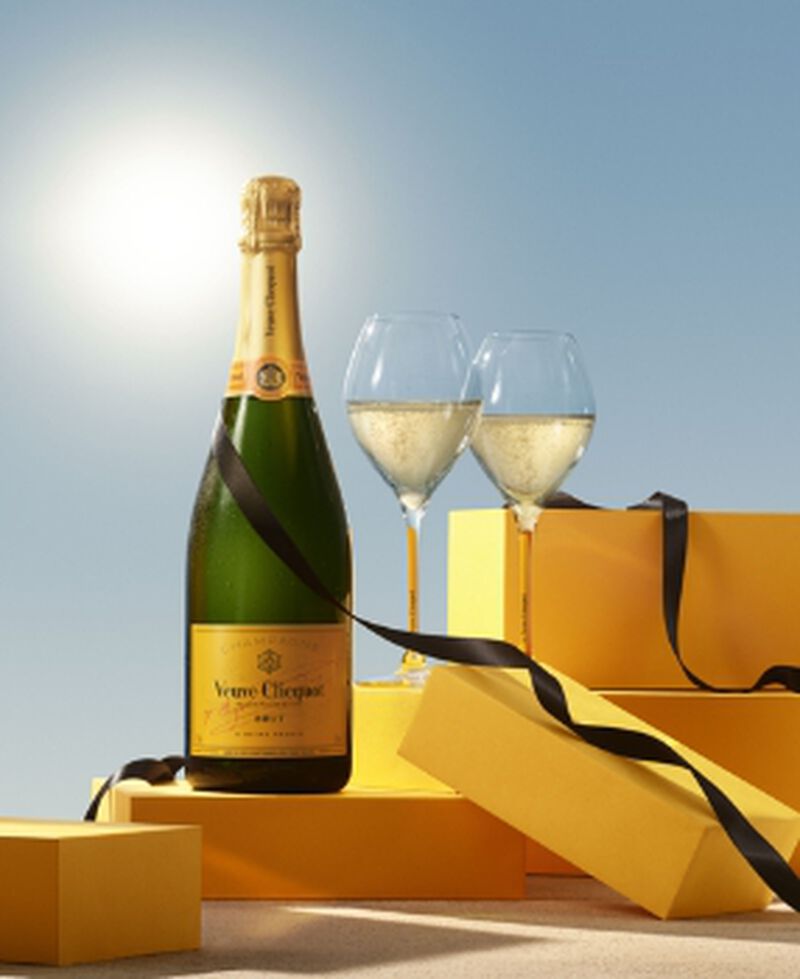 Bottle of Veuve Clicquot Yellow Label Champagne brut with two champagne flutes and gift boxes