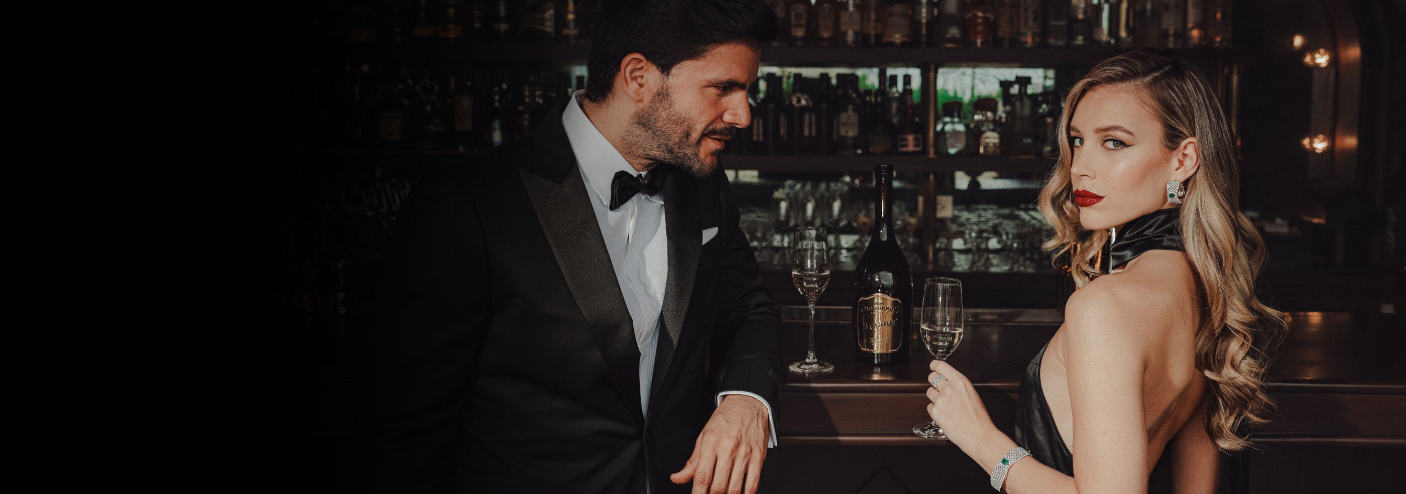 Two people in formal attire enjoying La Cachorra Tequila