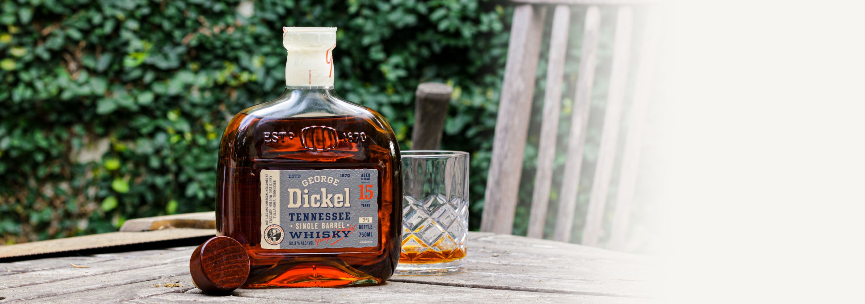 Bottle of George Dickel 15 Year Old Single Barrel S2B28 with rocks glass witting on a table outside