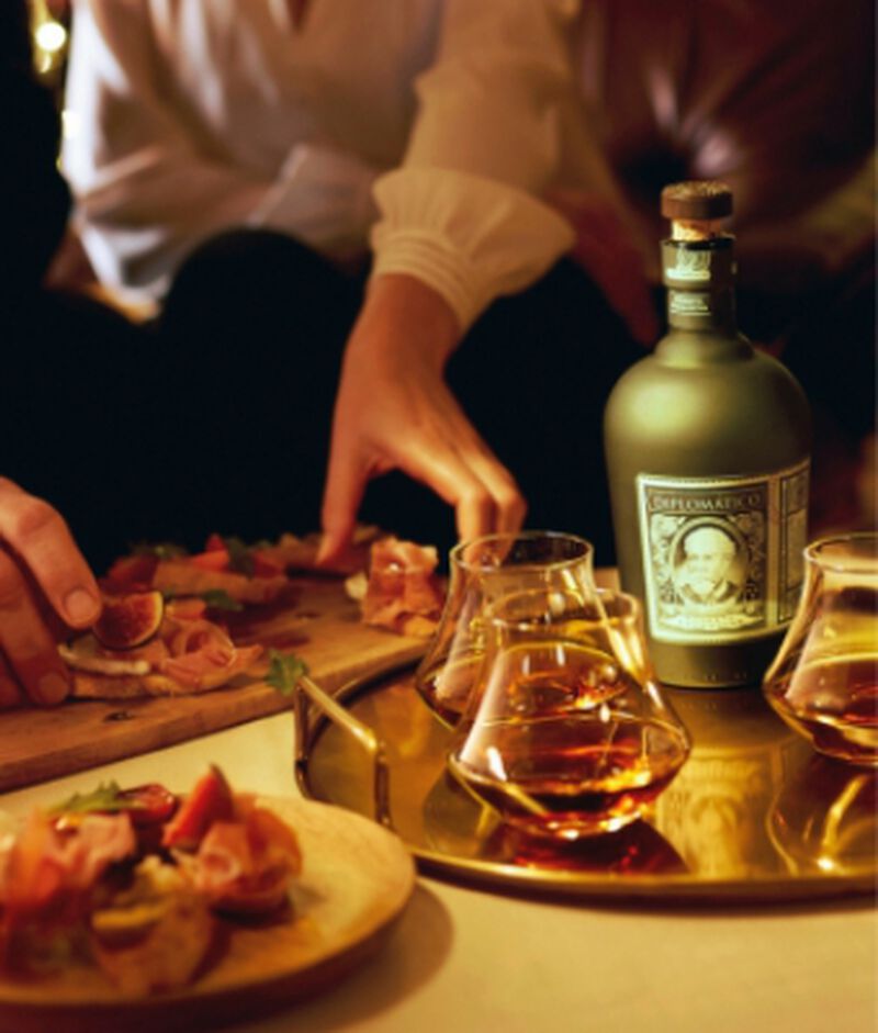 Bottle of Diplomatico Rum on a dinner table with food