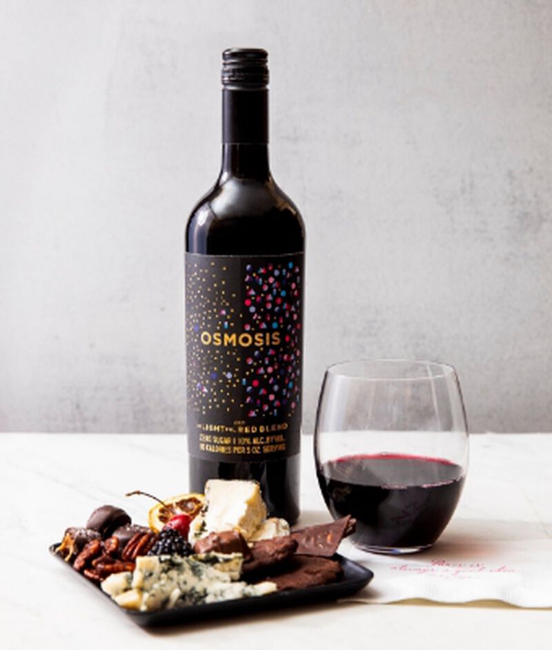 Bottle of Osmosis de-Light-ful Mendoza Red Blend with stemless glass and a charcuterie board