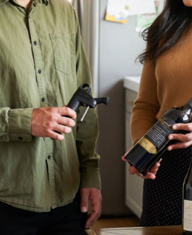 People holding a Coravin Pivot™ Black and a bottle of wine