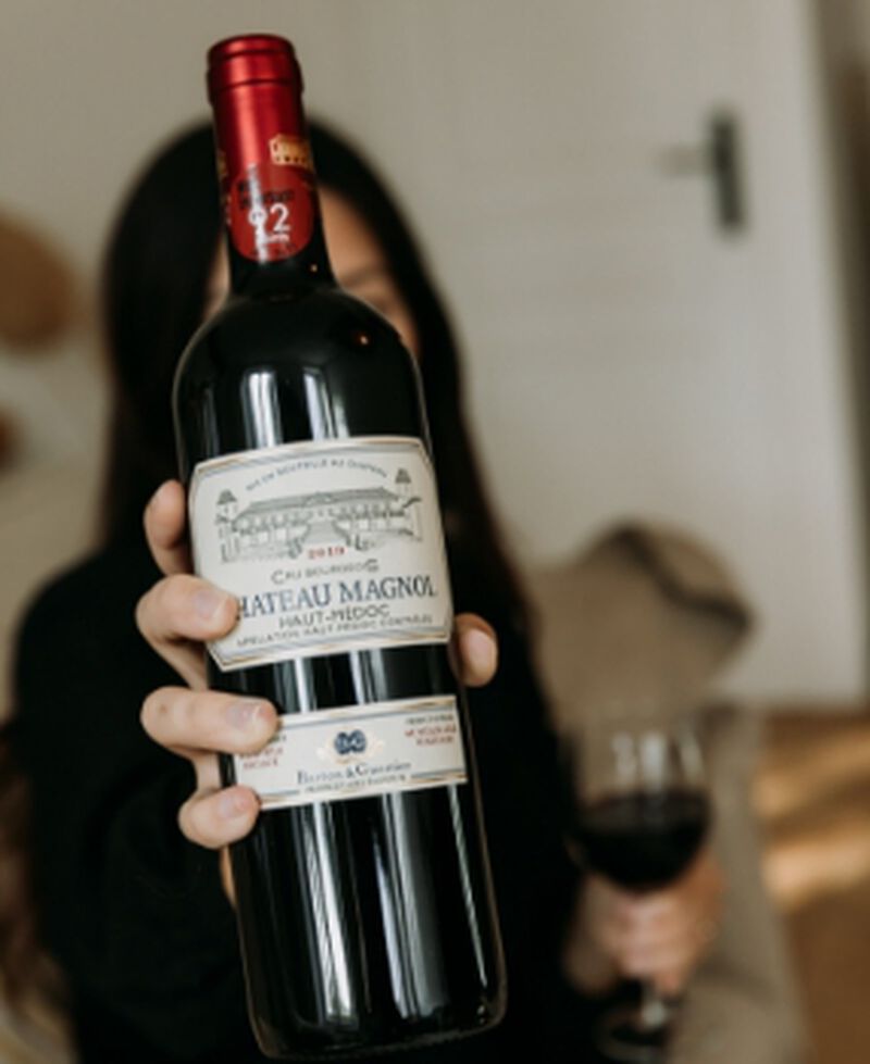 bottle of Chateau Magnol Haut-Medoc Bordeaux being held up