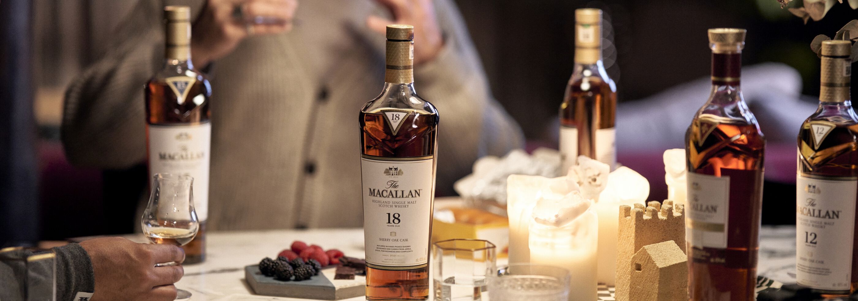 A dinner setting with several bottles of The Macallan of various vintages.