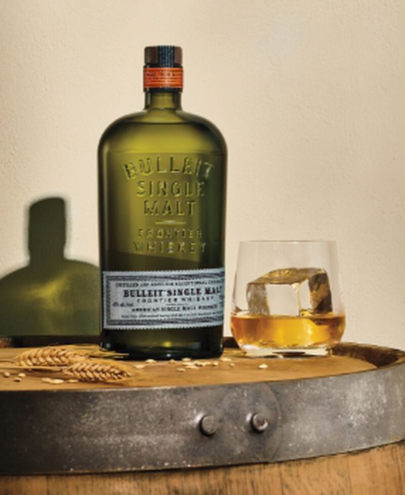 Bottle of Bulleit American Single Malt Whiskey with a cocktail