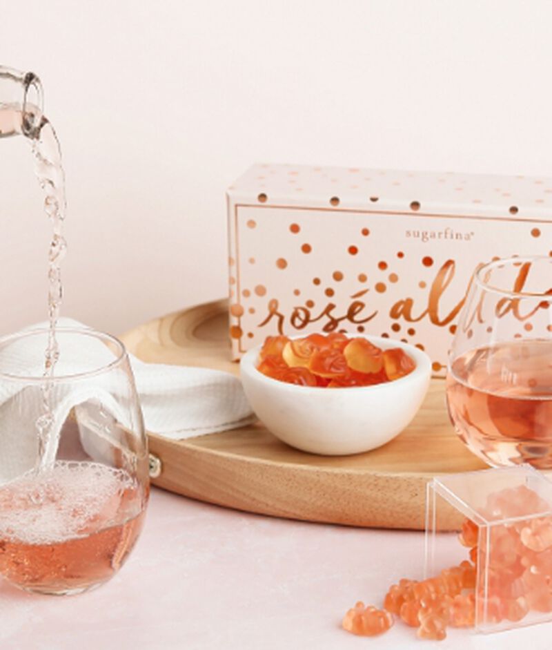 Sugarfina candies in a box and bowl with a glass of Rose being poured