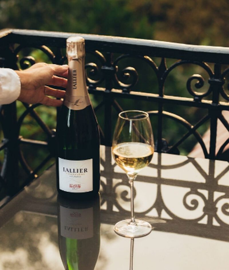 Bottle of Lallier Réflexion R.019 Brut Champagne with a glass outdoors