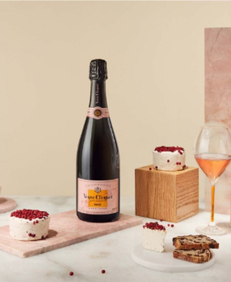Bottle of Veuve Clicquot Rosé with a champagne flute and treats