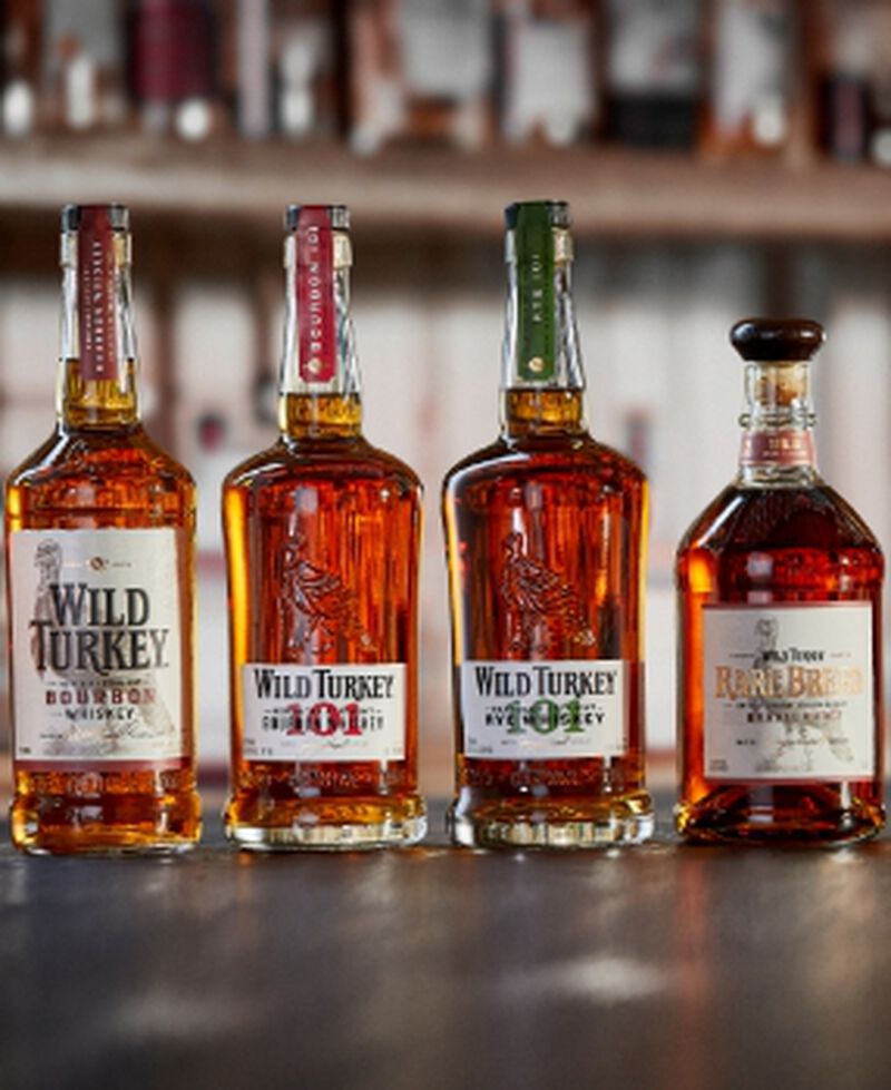 Four bottles of Wild Turkey sitting on a bar