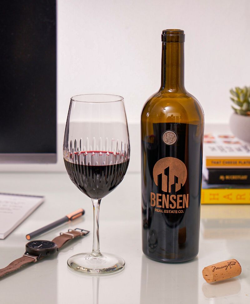 A custom engraved bottle of wine used as a corporate gift for a real estate company