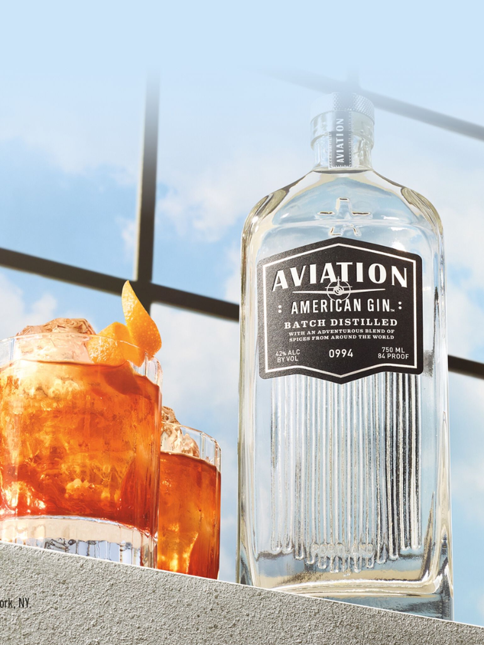 Bottle of Aviation American Gin with a Negroni cocktail