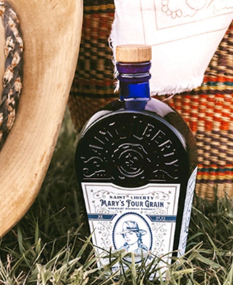 Bottle of Saint Liberty Whiskey sitting in the grass