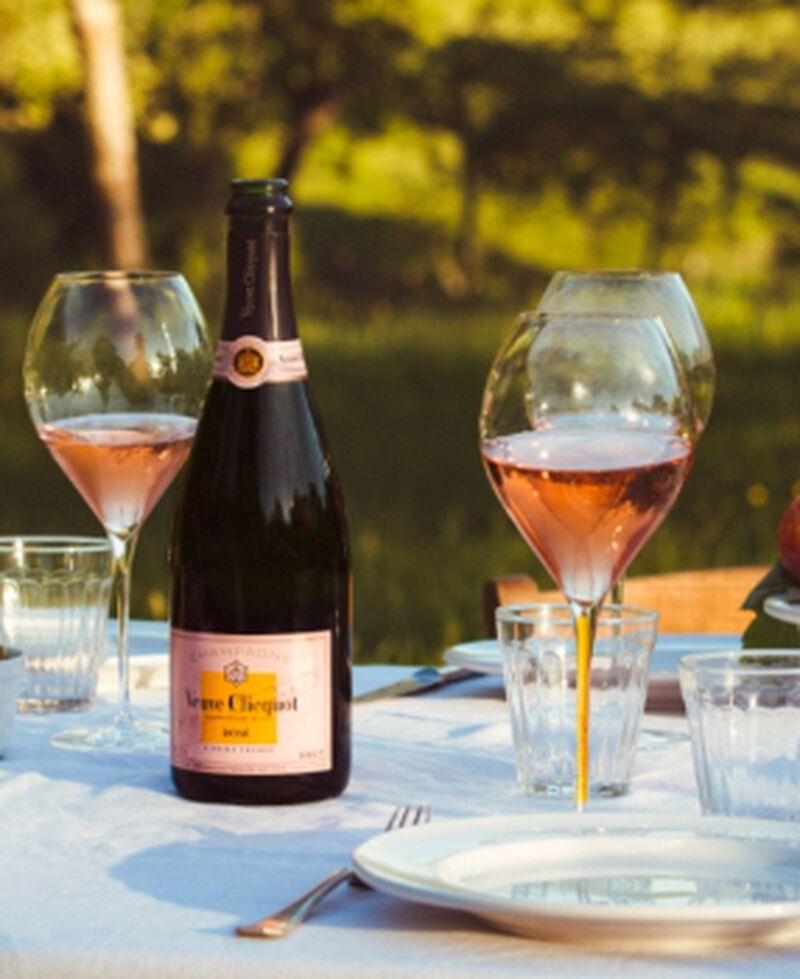 Bottle of Veuve Clicquot Rosé outside with glass glasses on a table