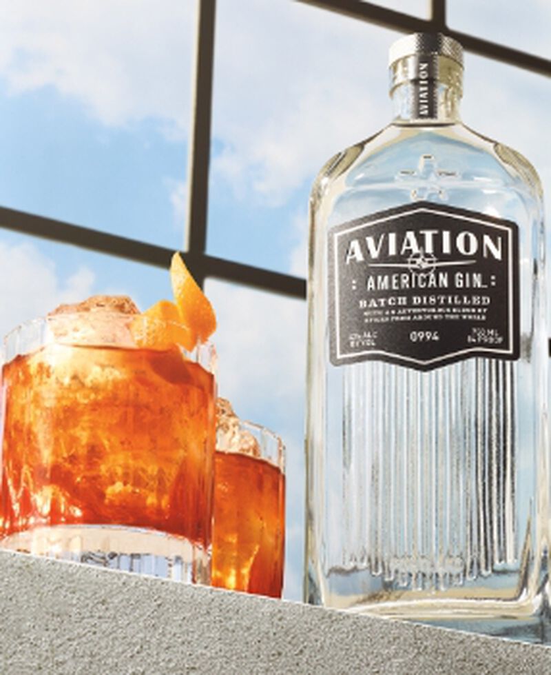 Bottle of Aviation American Gin with two cocktails