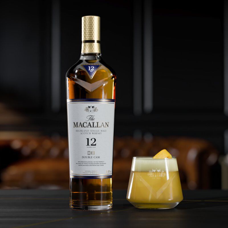 Bottle of The Macallan Double Cask 12 Years Old, beside it a cocktail in a tumbler with a lemon garnish