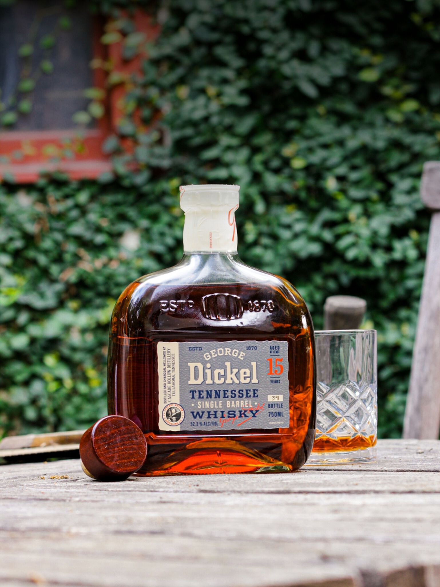 Bottle of George Dickel 15 Year Old Single Barrel S2B28 with rocks glass witting on a table outside