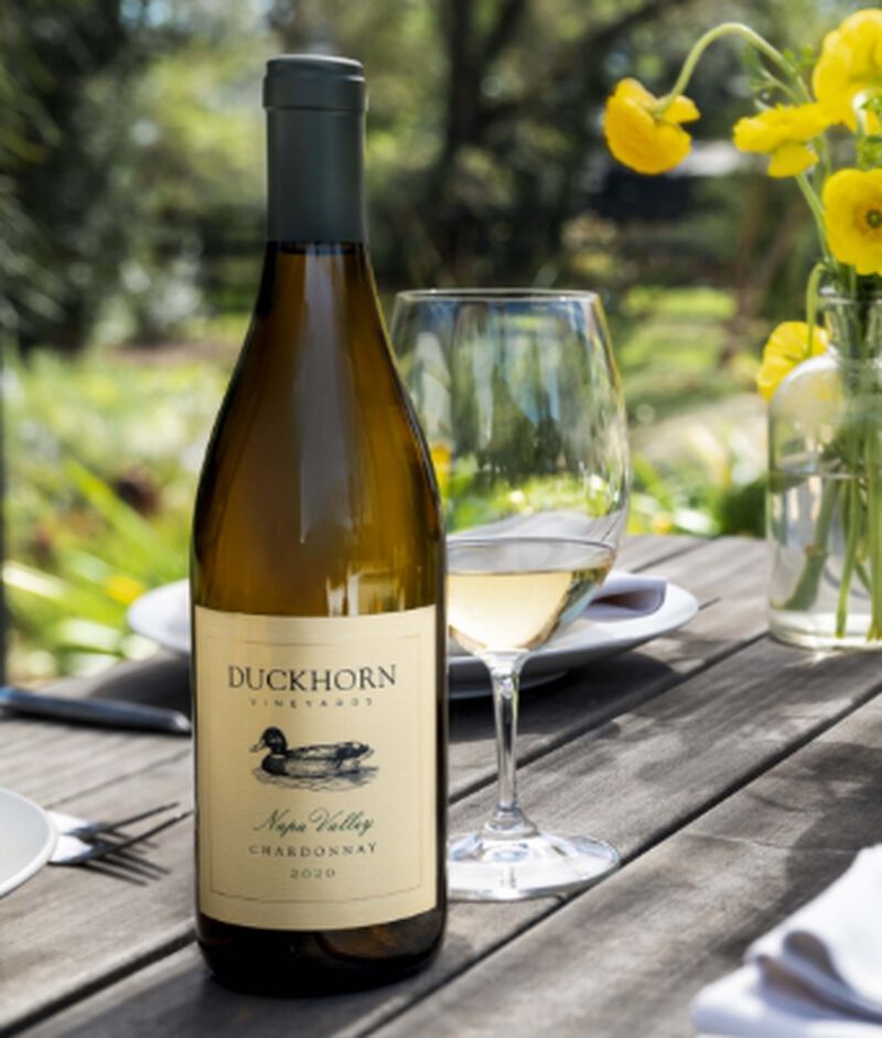 Bottle of Duckhorn Vineyards Napa Valley Chardonnay with wine glasses outside