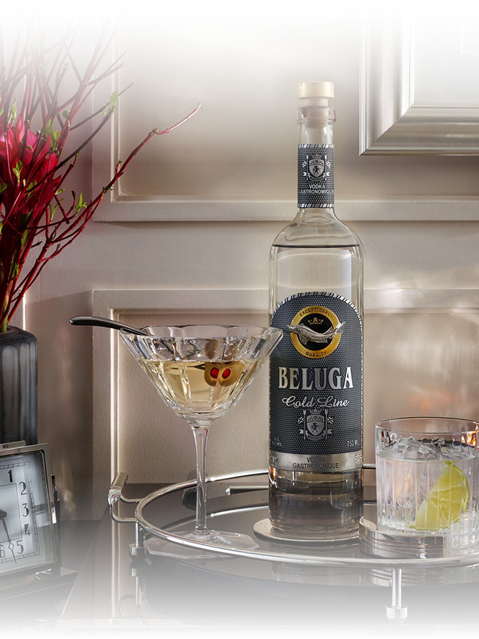 Bottle of Beluga Gold Line Vodka with cocktail tools and martini glasses